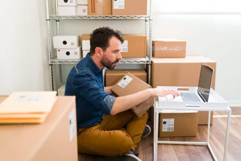 Commerçant en ligne vérifiant une commande sur son ordinateur