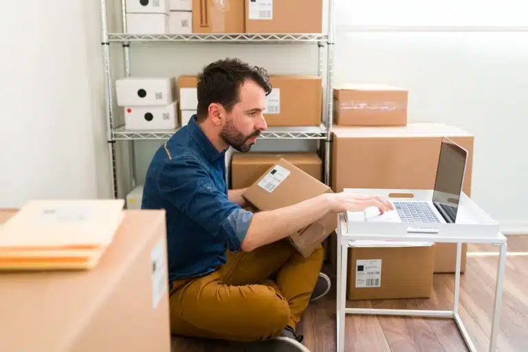 Commerçant en ligne vérifiant une commande sur son ordinateur